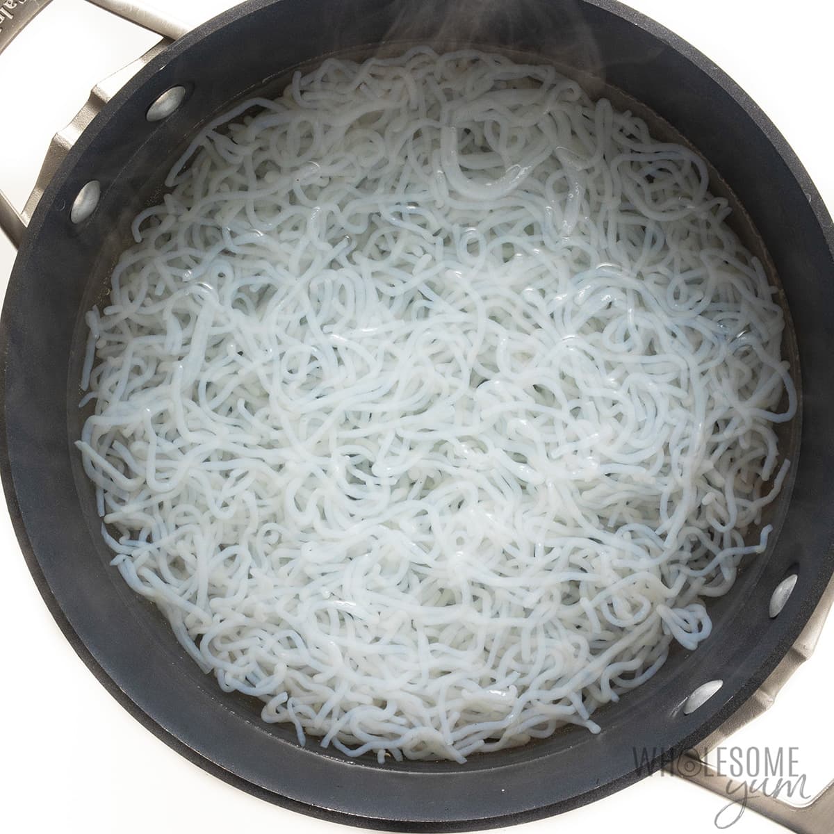 Shirataki noodles boiling in a large pot.
