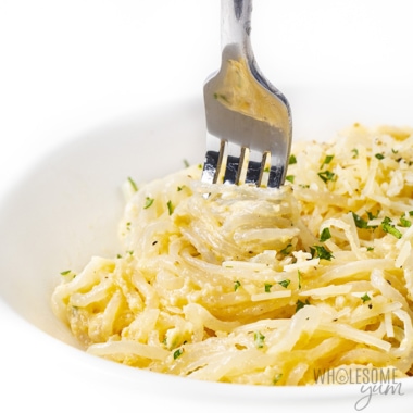 Shirataki noodles in a garlic parmesan sauce being wrapped around a fork