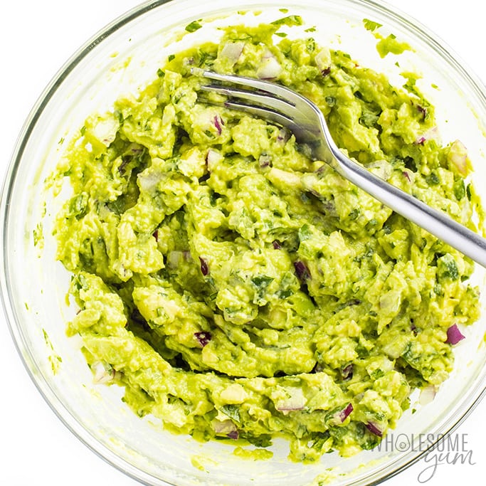 Mashed guacamole in glass bowl