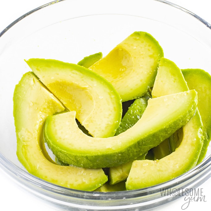Avocado slices in a bowl with lemon juice