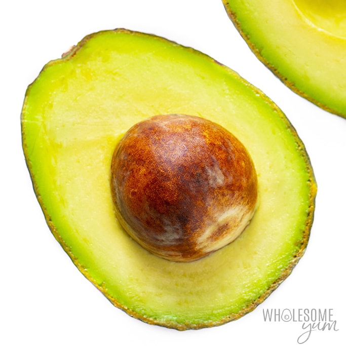 Avocado cut in half with pit.