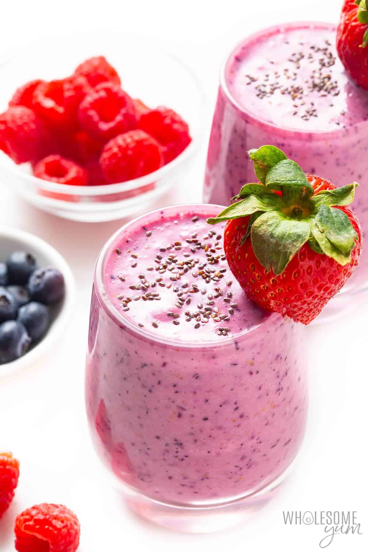 Low carb protein shakes in glasses with berries in background.
