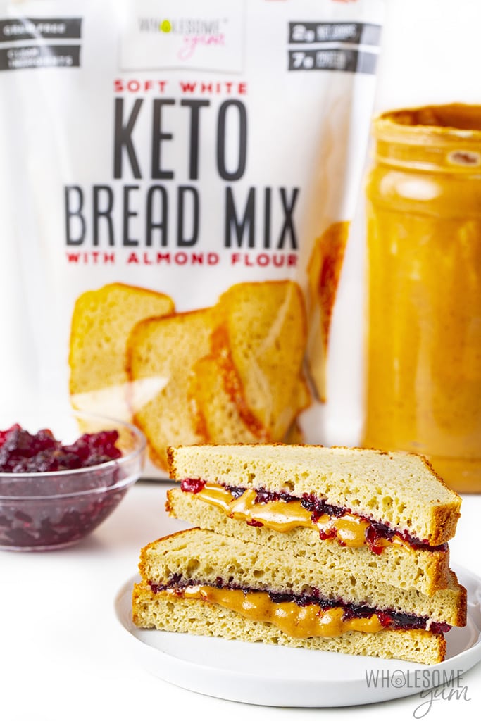 Keto peanut butter and jelly sandwich with Wholesome Yum Keto Bread Mix in the background