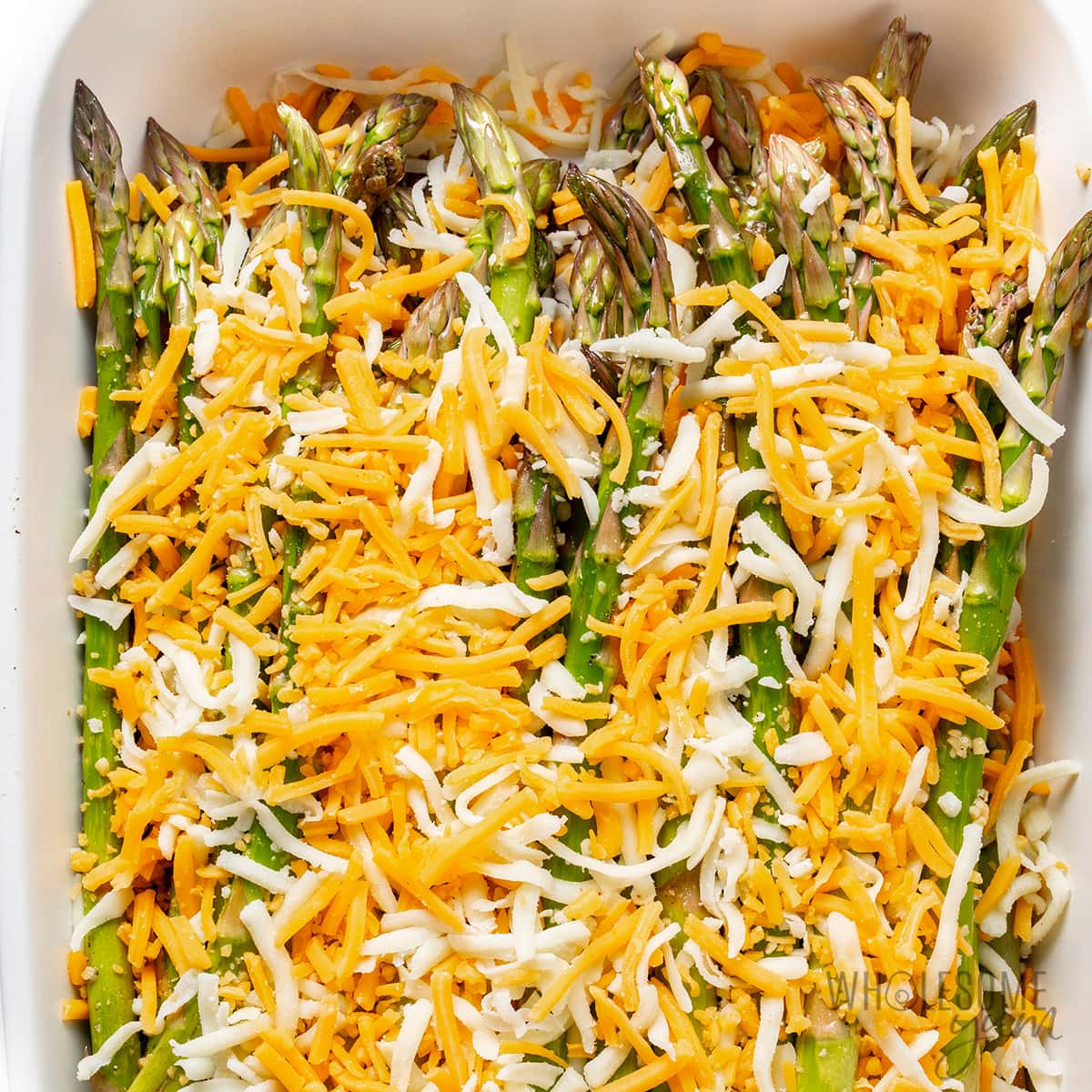 Layers of veggies and cheese in a baking dish.