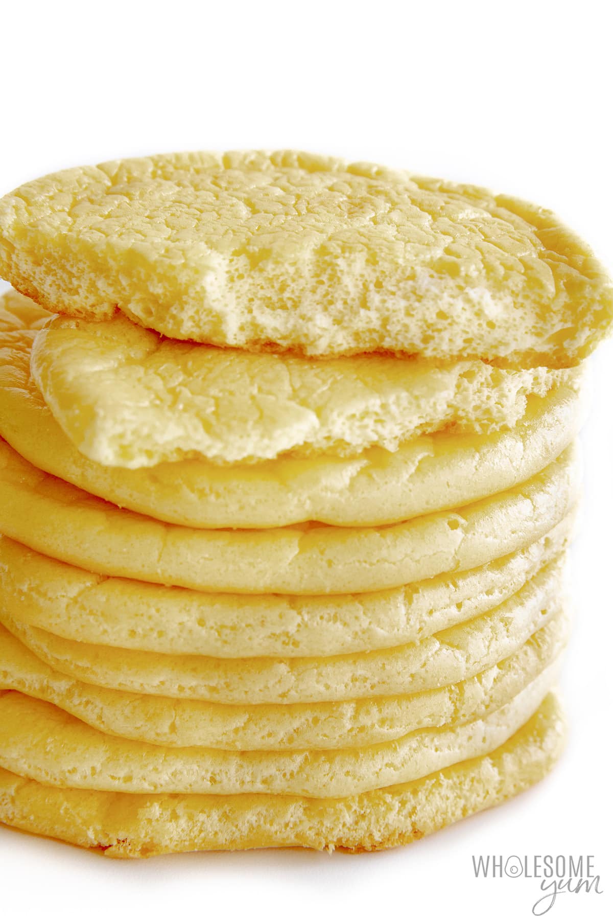 Cloud bread recipe stacked with one piece torn in half.
