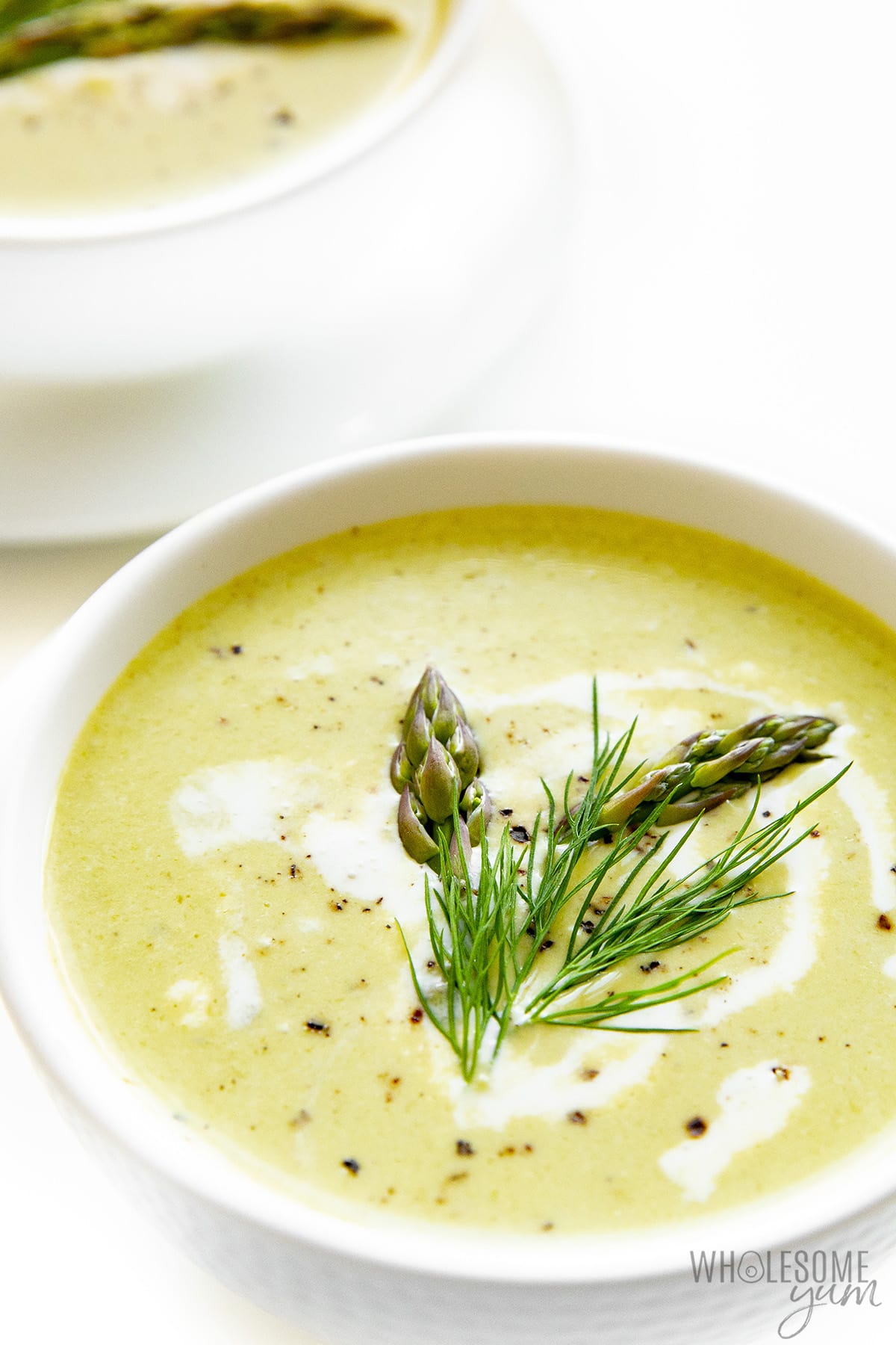 Two bowls of creamy asparagus soup.
