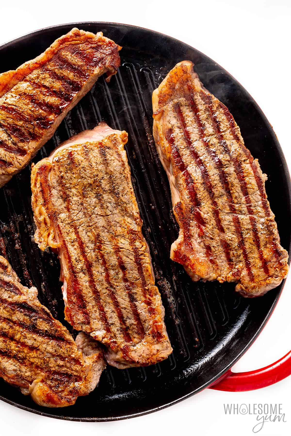 Showing how to cook New York strip steak in a cast iron pan.
