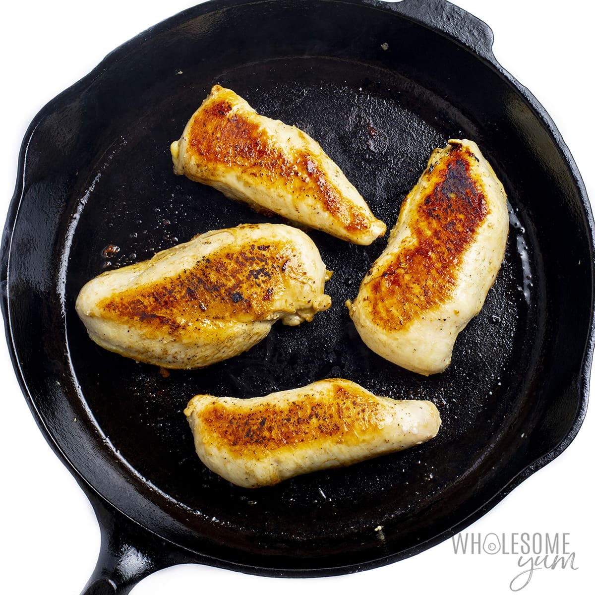 Pan seared chicken breasts in a cast iron skillet.