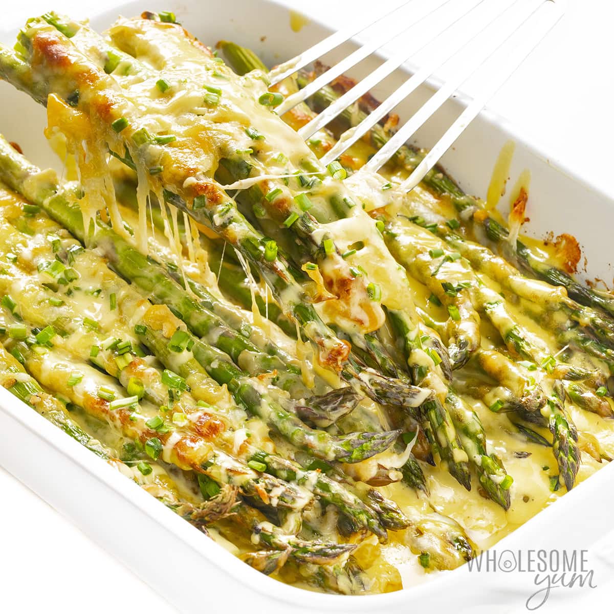 Cheesy asparagus casserole recipe with a spatula
