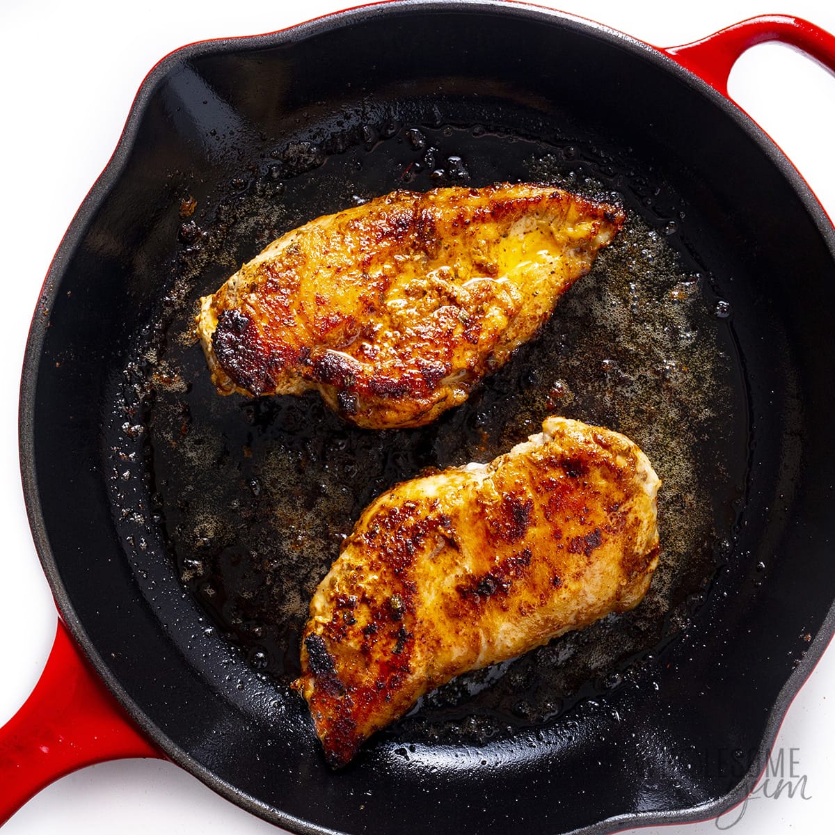 Seared chicken in a skillet.