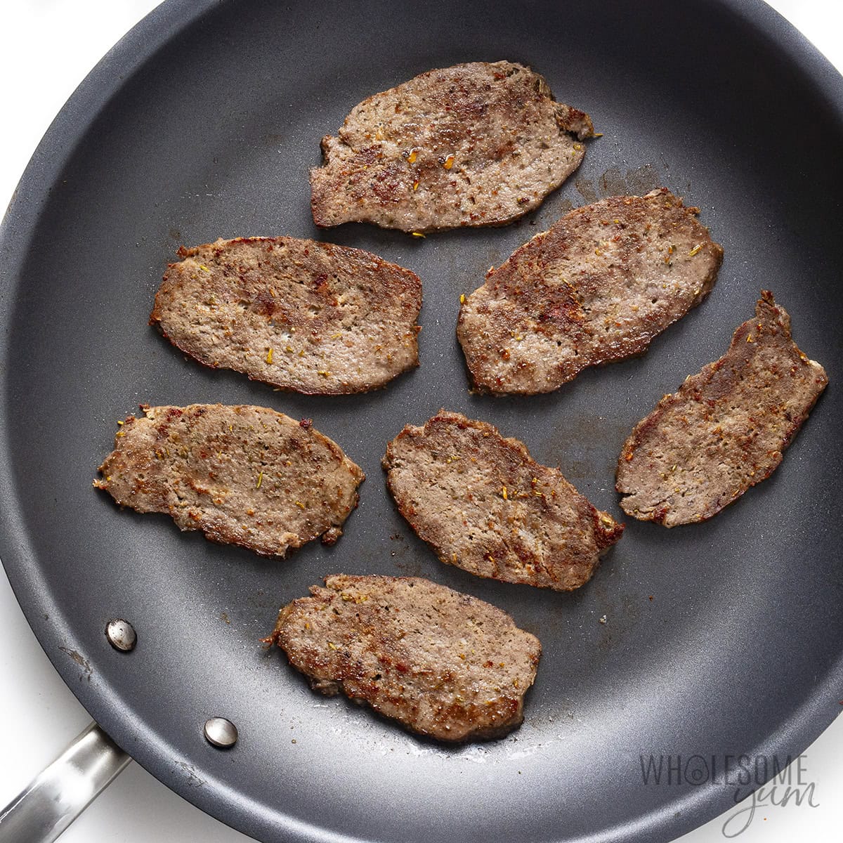 Gyro meat fried on both sides in a skillet.