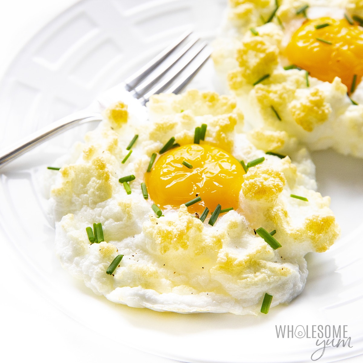 Baked cloud eggs on a plate with a fork
