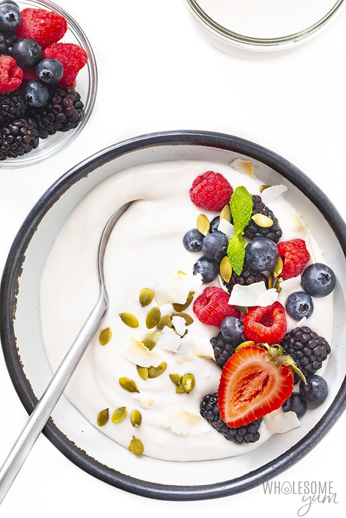 Dairy free yogurt in a bowl with berries and a bowl of berries next to it