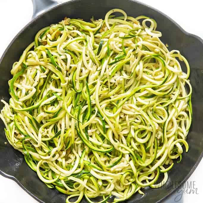 Cooked zucchini noodles in skillet.