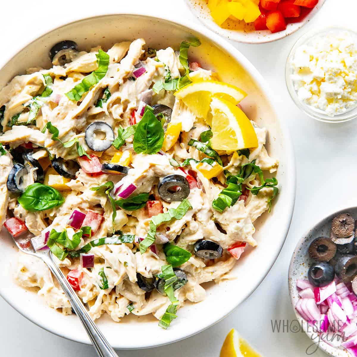 Finished Mediterranean chicken salad recipe garnished with fresh basil and lemon.