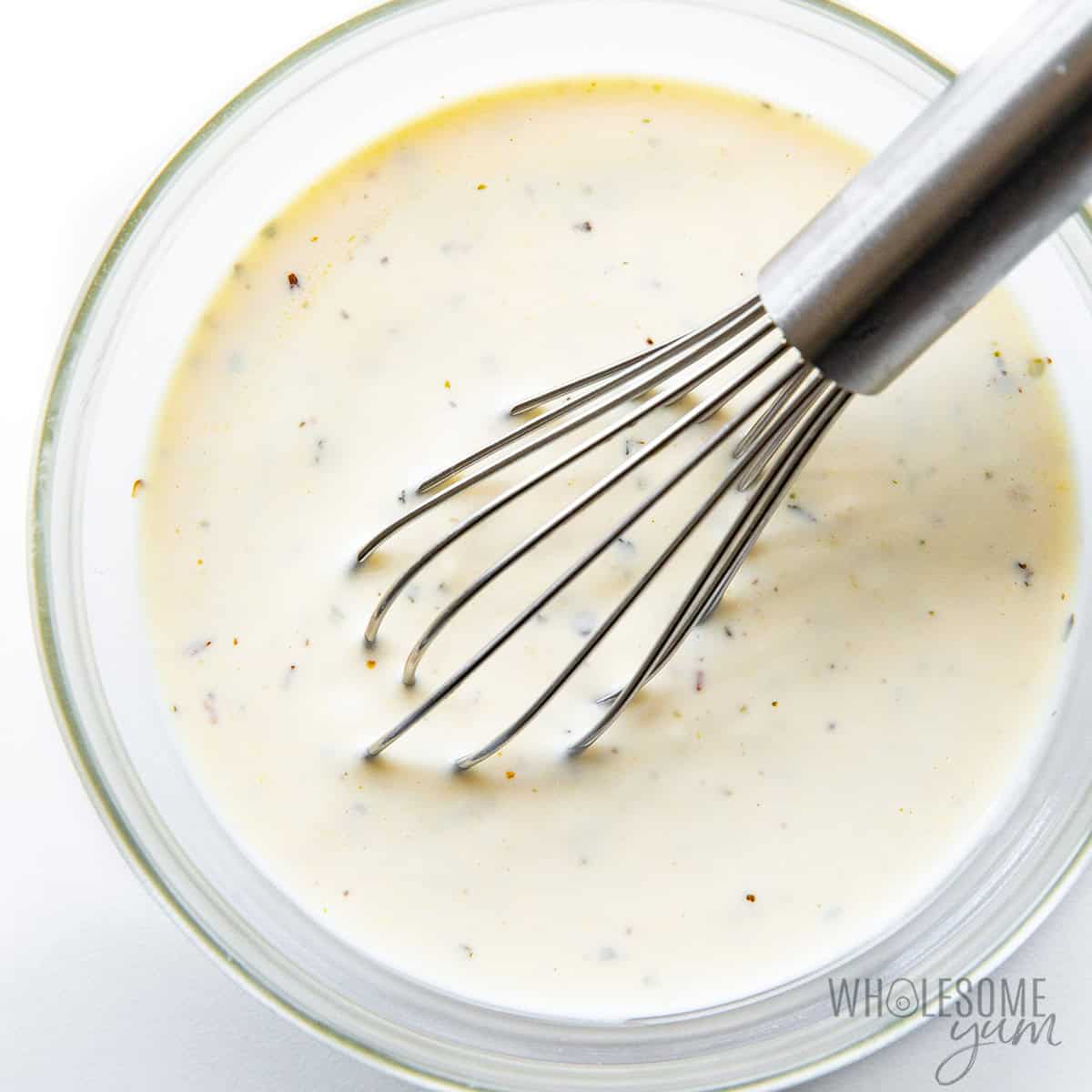 Creamy lemon dressing whisked in a small bowl.