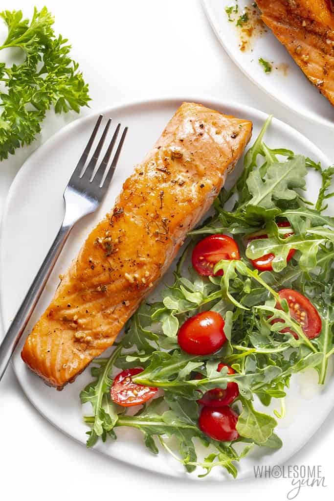Pan fried salmon on a plate with salad