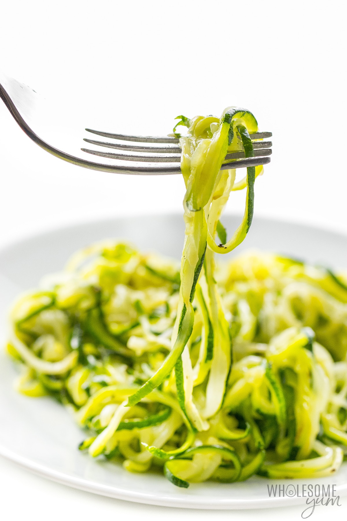 Zucchini noodles scooped up with a fork.