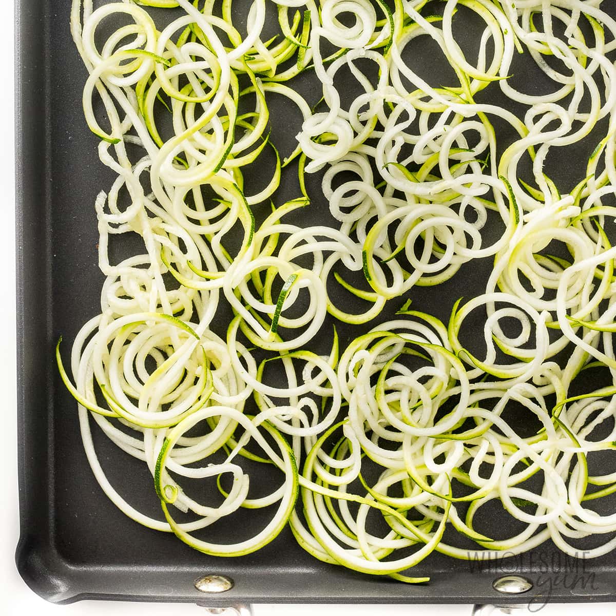 Raw zoodles on a baking sheet.