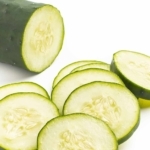 Cucumber cut into slices on white background.