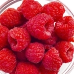 Raspberries in a bowl on white background.
