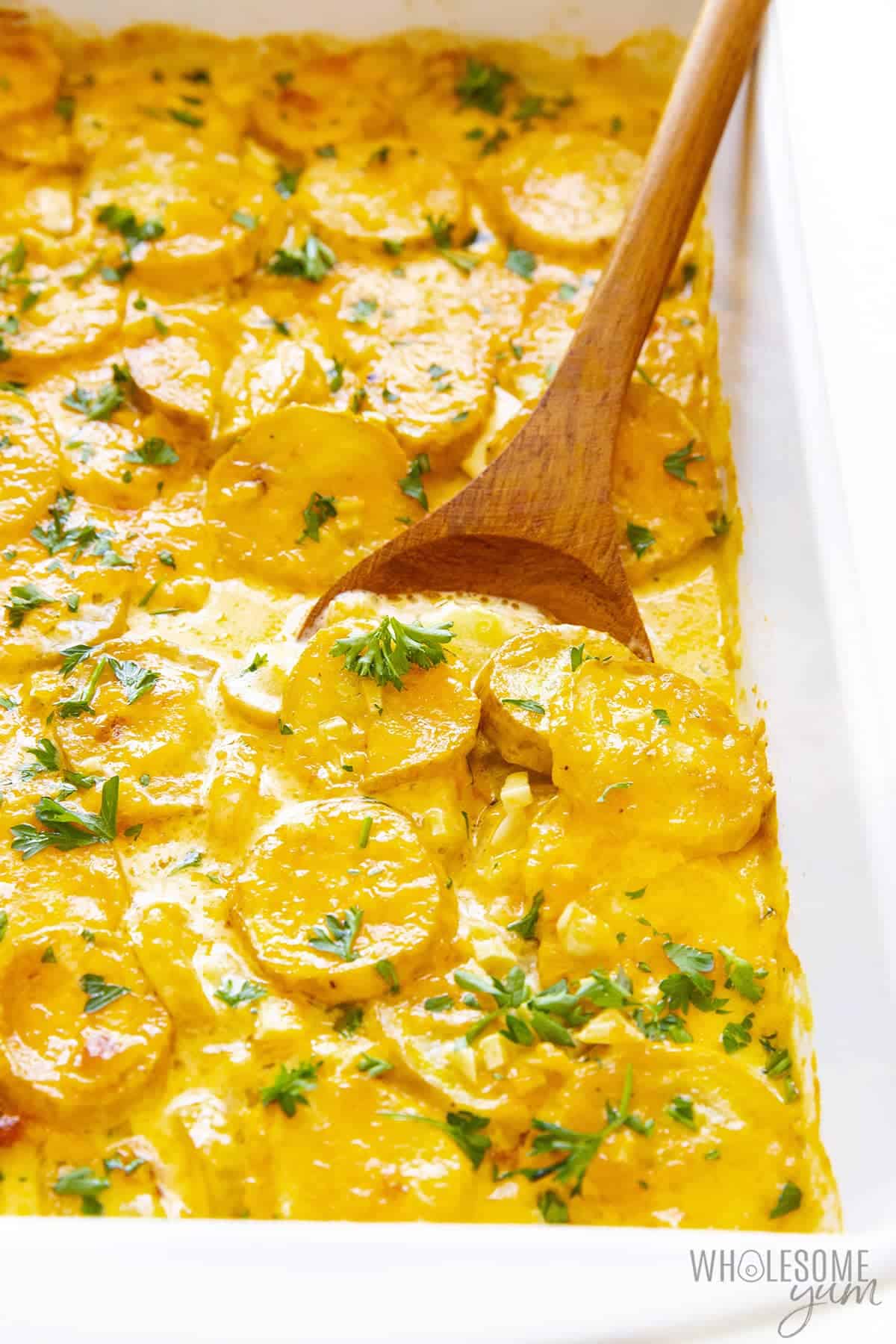 Cheesy yellow squash casserole in a baking dish.