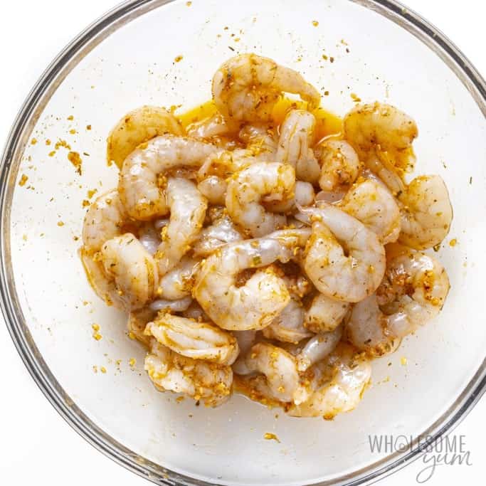 Shrimp coated in marinade in a bowl