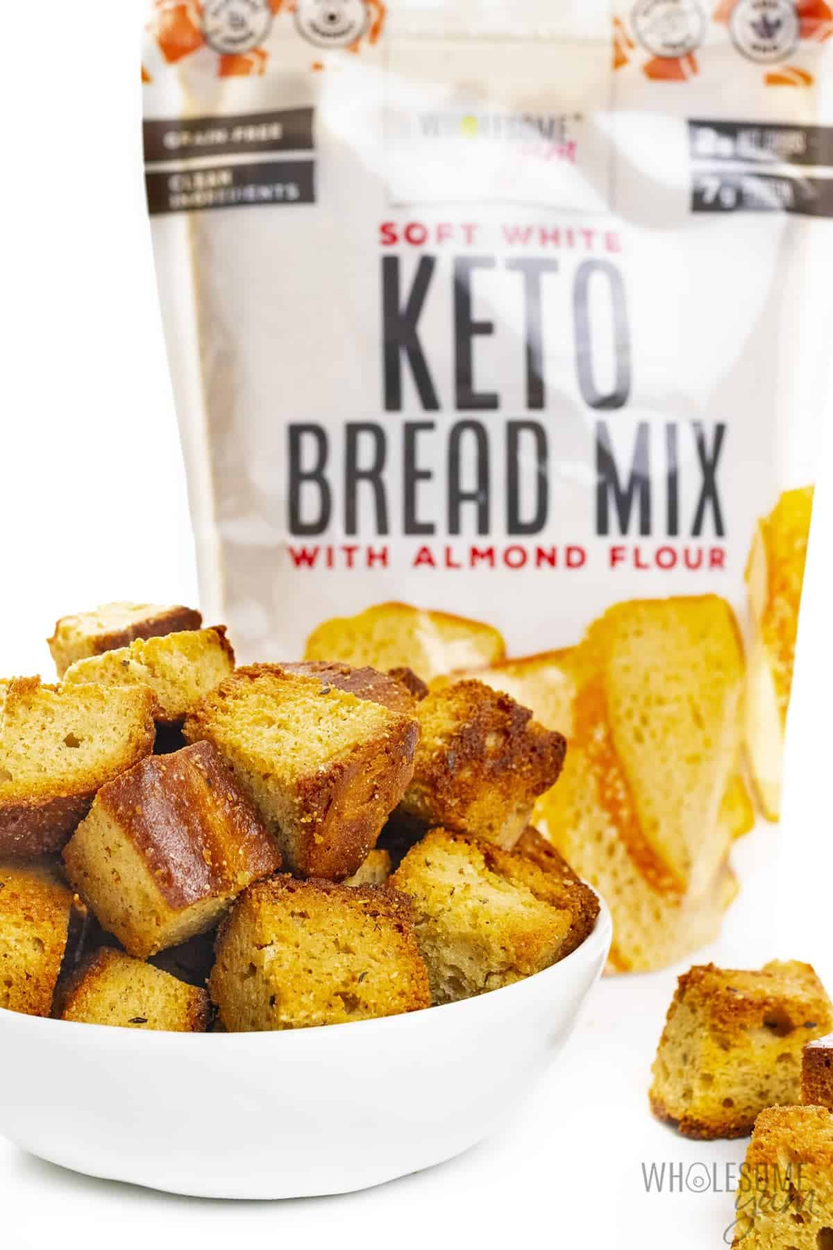 Bowl of keto croutons with Wholesome Yum Bread Mix behind it