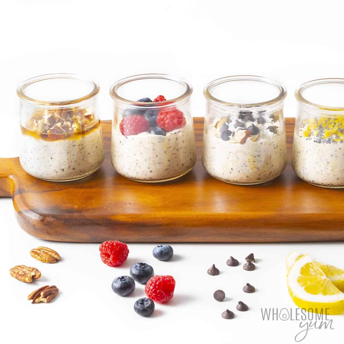 Flavors of keto overnight oats in jars on a wooden cutting board