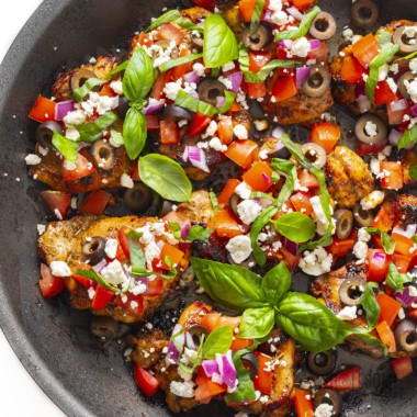 Mediterranean chicken recipe made in a skillet with fresh toppings.