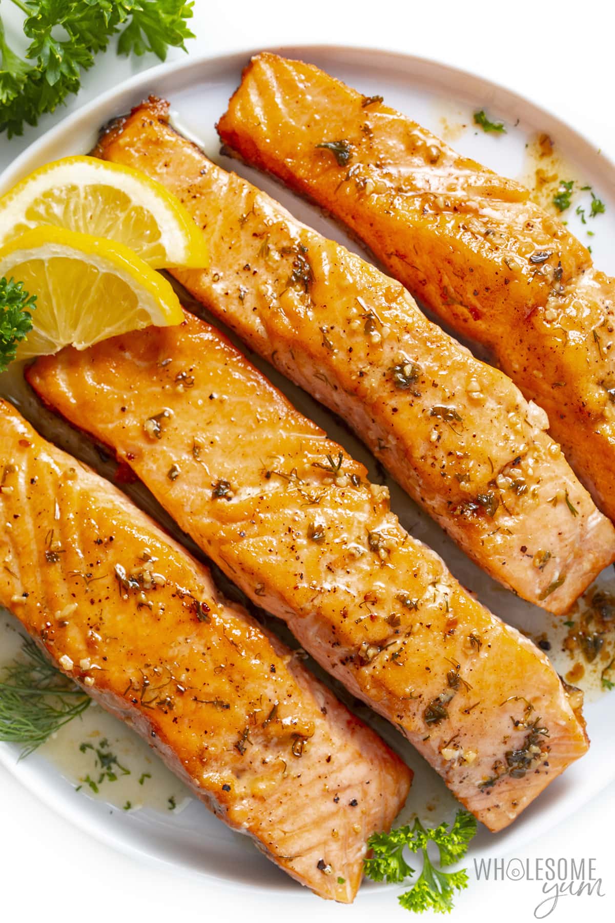Pan seared salmon recipe with lemon slices and parsley.
