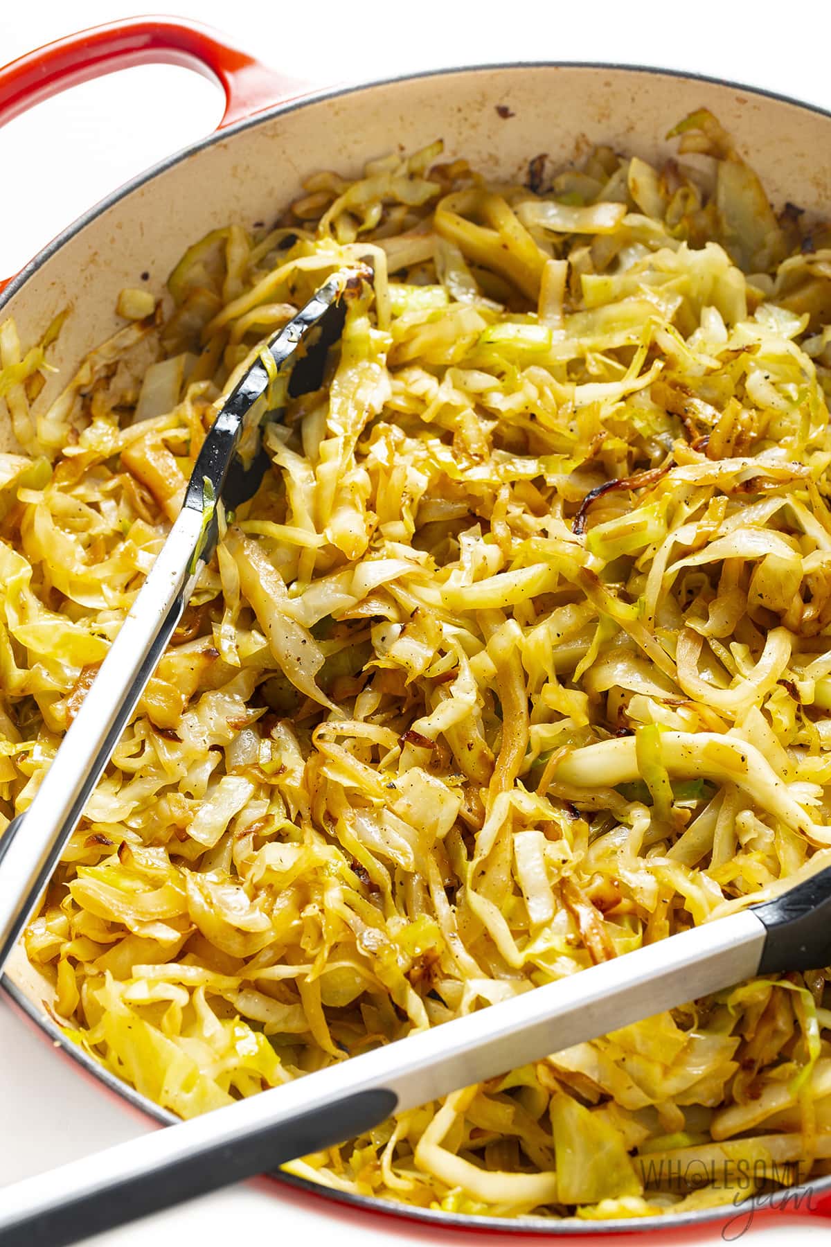 Sauteed cabbage recipe with tongs.
