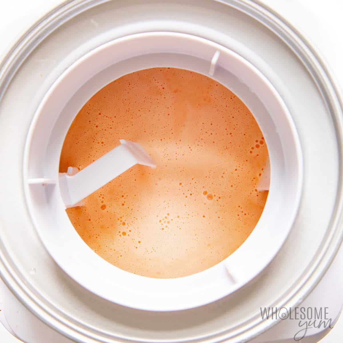 Churning the sugar free orange sherbet in an ice cream maker.