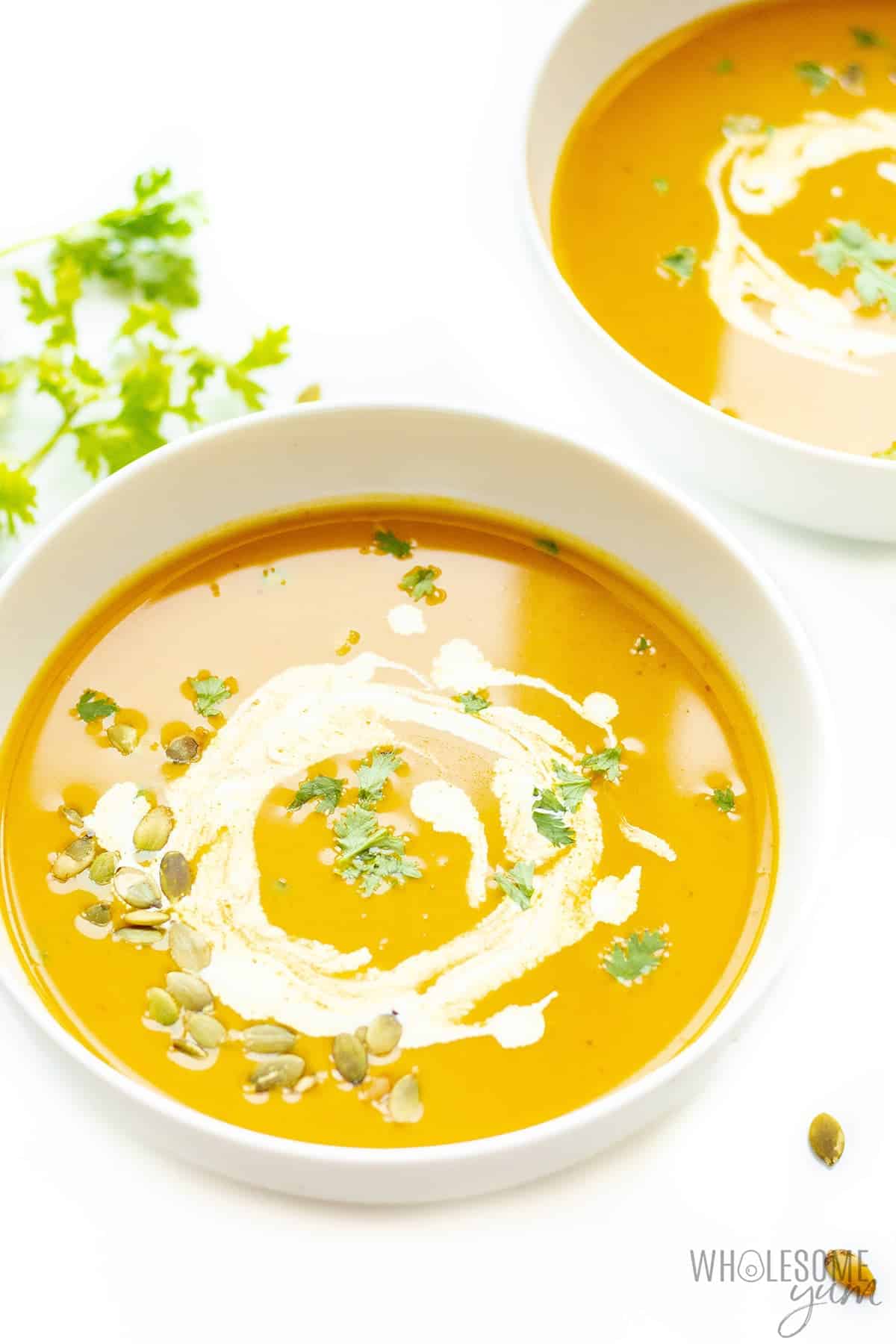 Bowls of creamy pumpkin soup with garnish