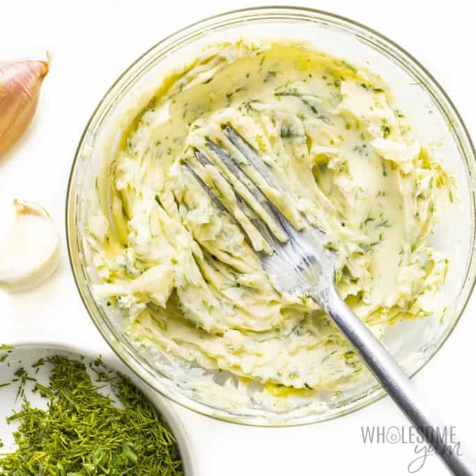 Garlic compound butter mashed with a fork in a small bowl.