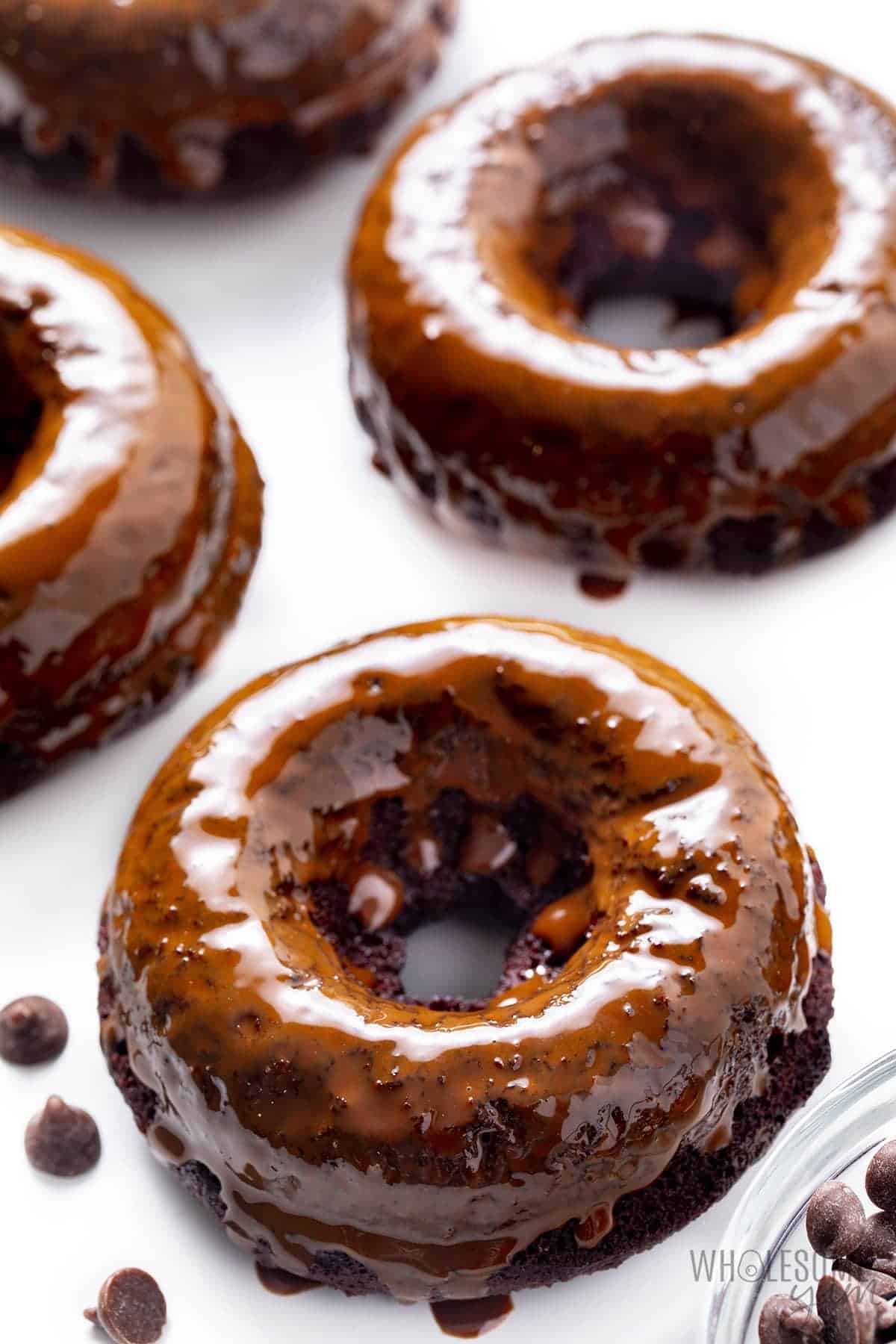 Protein packed donuts lined up next to chocolate chips in a bowl