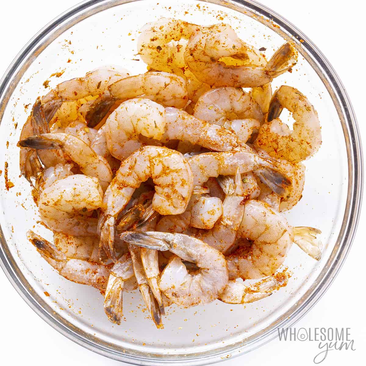 Seasoned raw shrimp in a glass bowl
