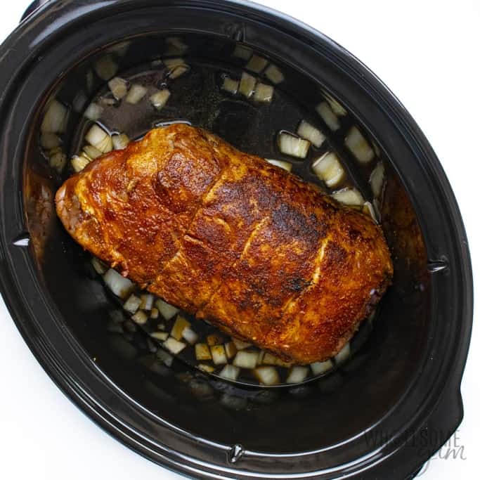 Seared pork in crock pot with onions