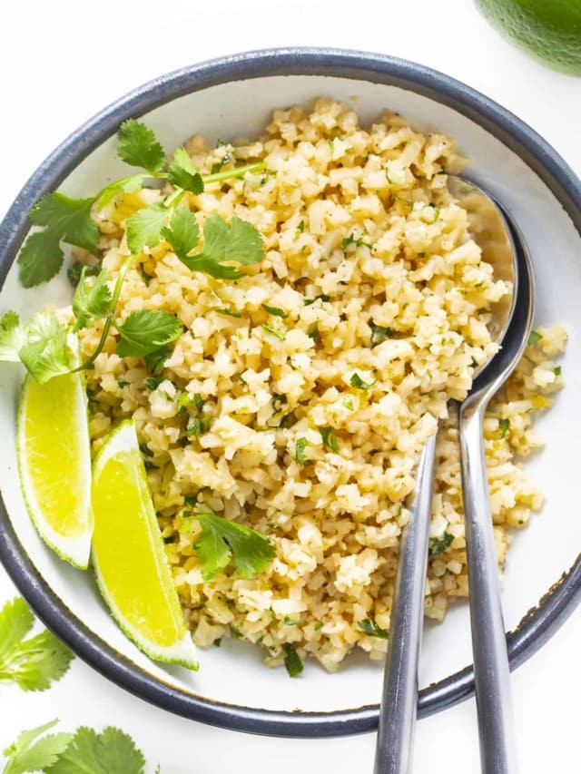 Cauliflower cilantro lime rice in a bowl with serving spoons
