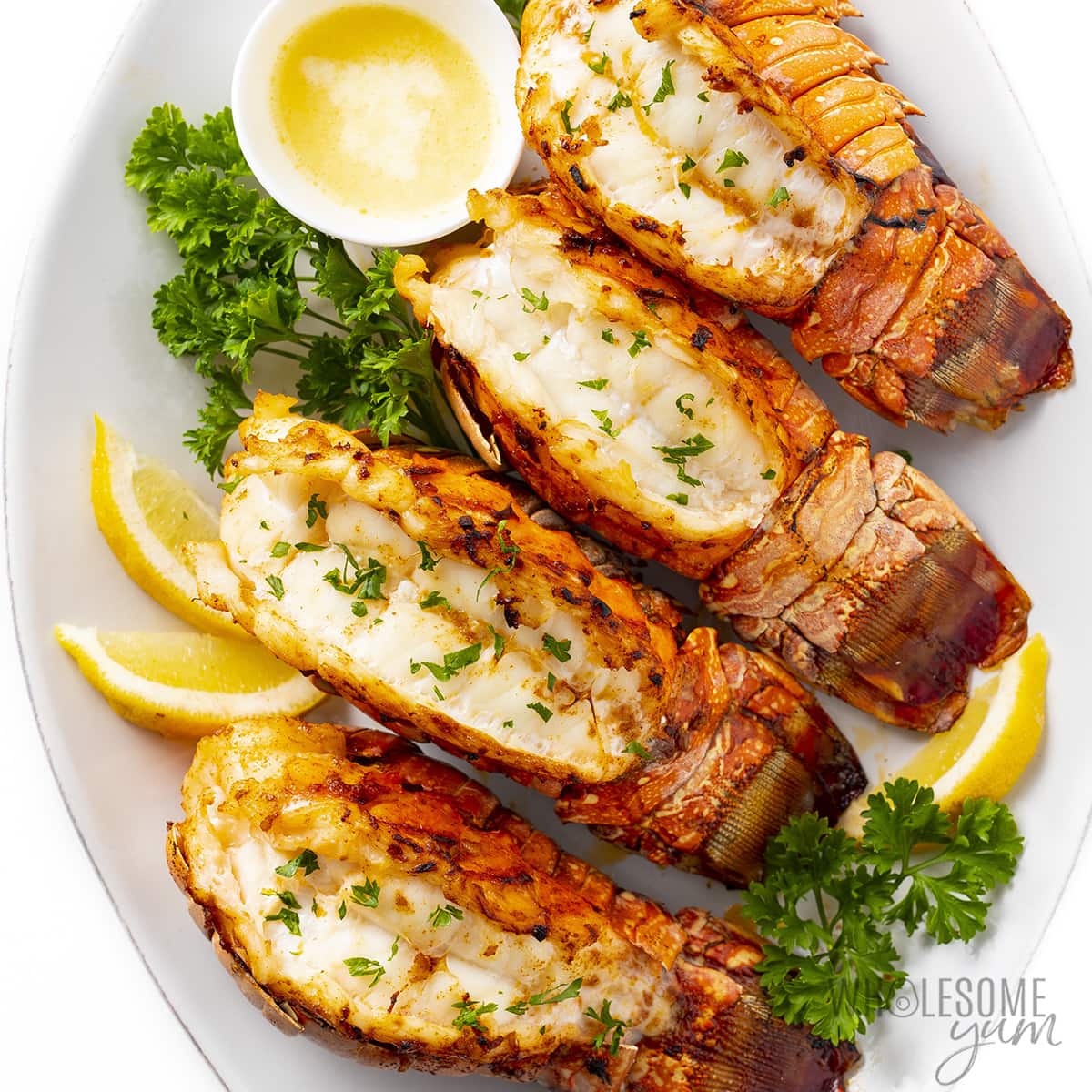 Broiled lobster tails on a platter.