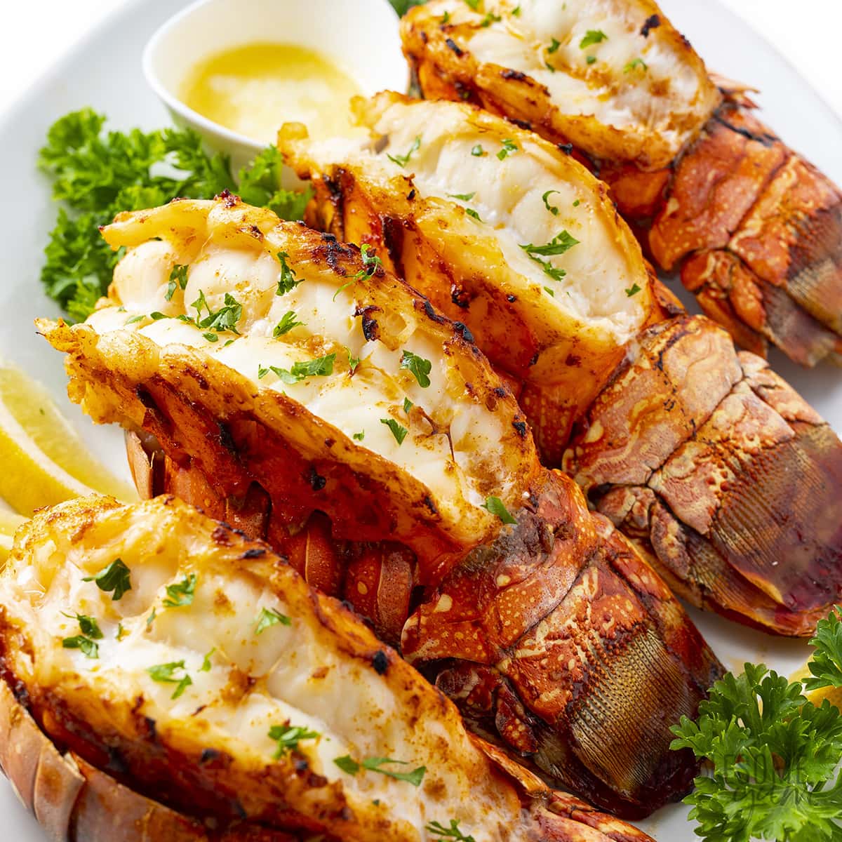 Lobster tails with lemon wedges and parsley.