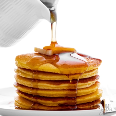 Coconut flour pancakes stack with syrup poured over them.