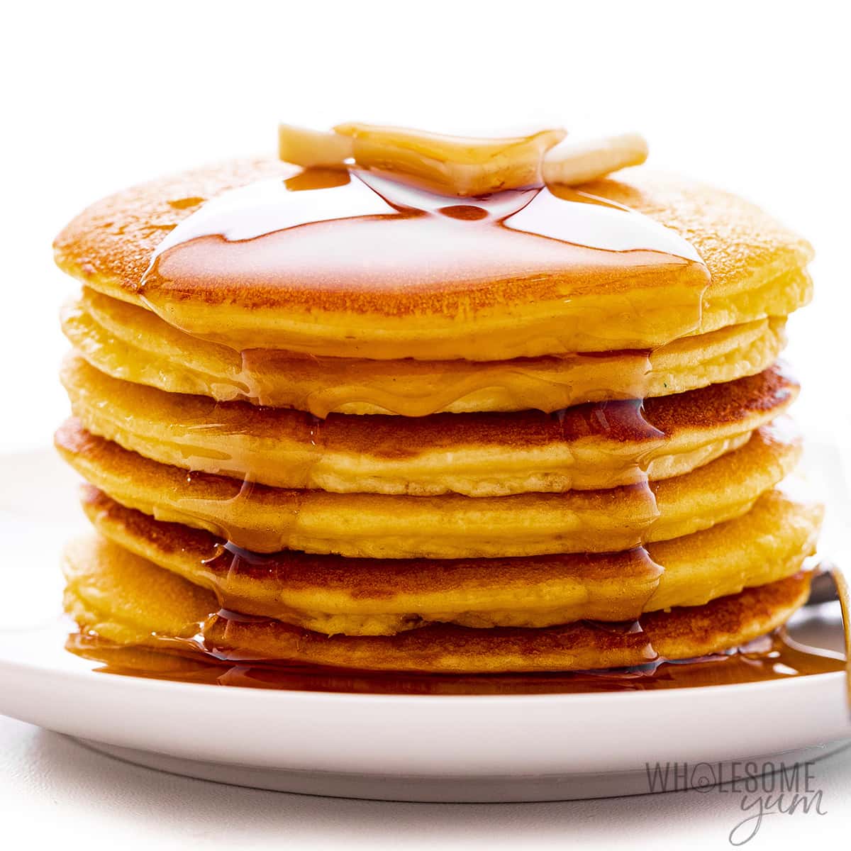 Stack of coconut flour pancakes with butter and syrup.