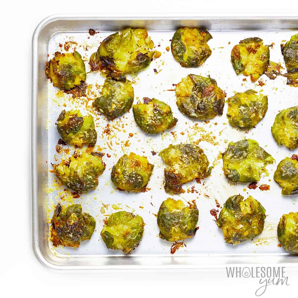 Roasted smashed brussels sprouts in baking pan.