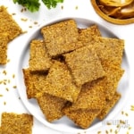 Keto flax seed crackers plated with scattered flax seeds