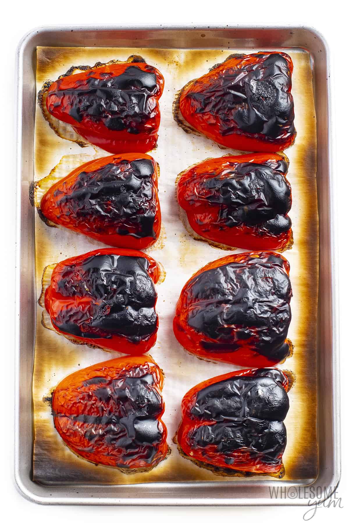 Charred red peppers on a sheet pan
