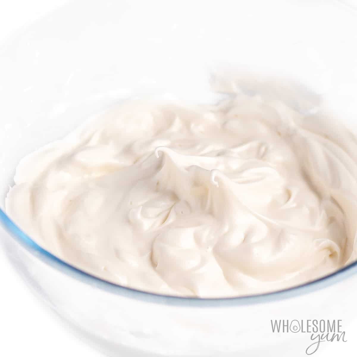 Whipped egg whites with stiff peaks in a glass bowl