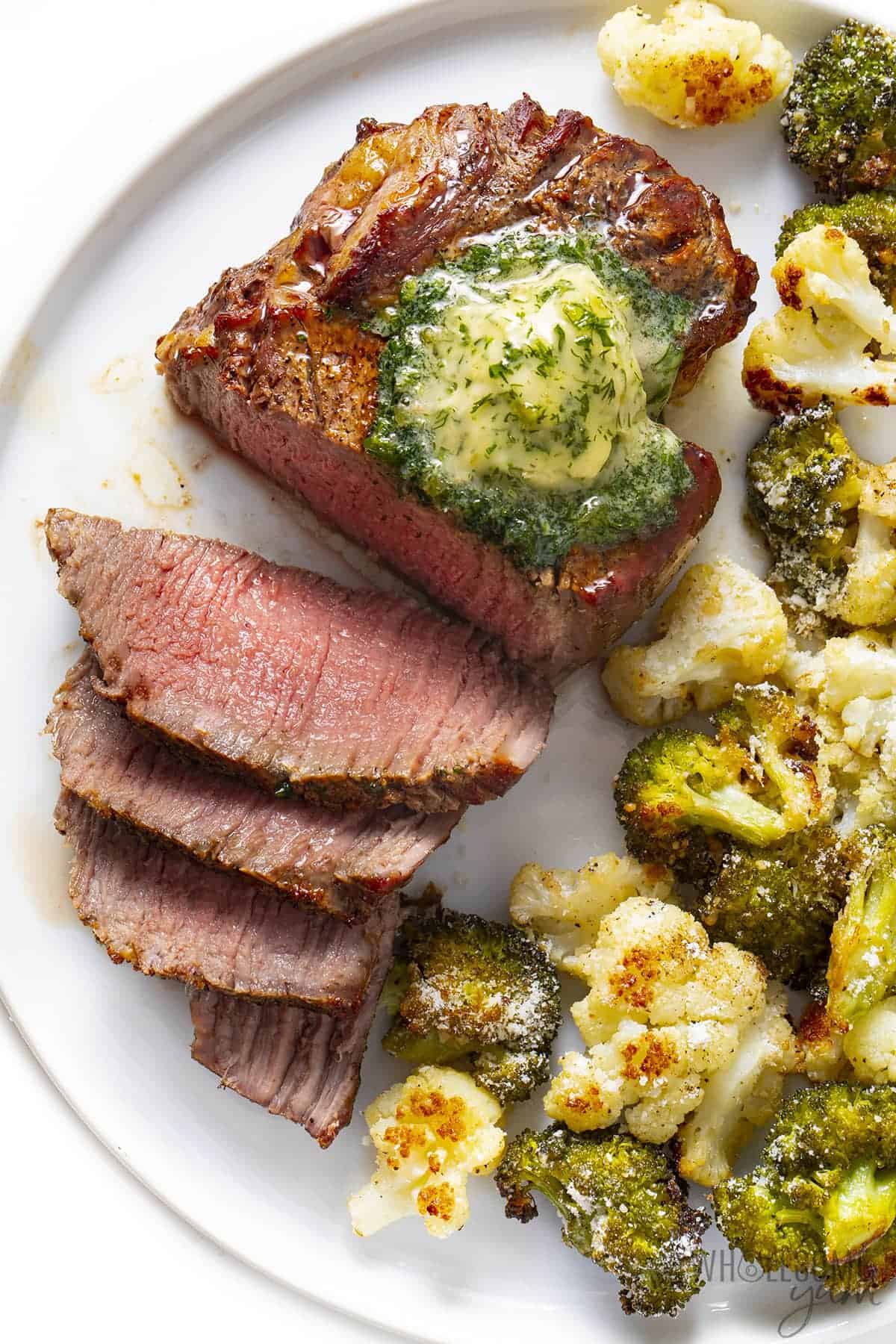 Perfect air fryer filet mignon on a plate with broccoli and cauliflower