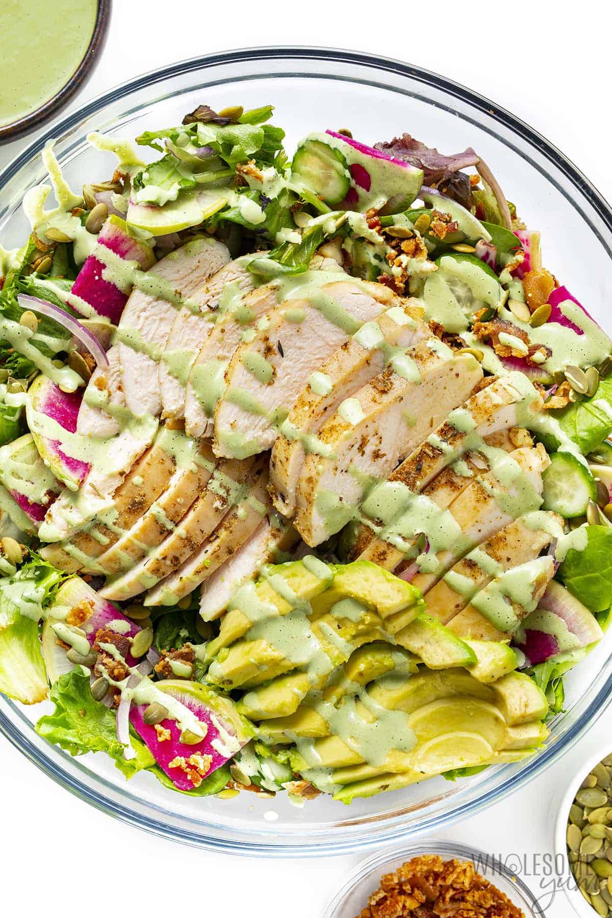 Green goddess chicken salad with garnishes in bowls