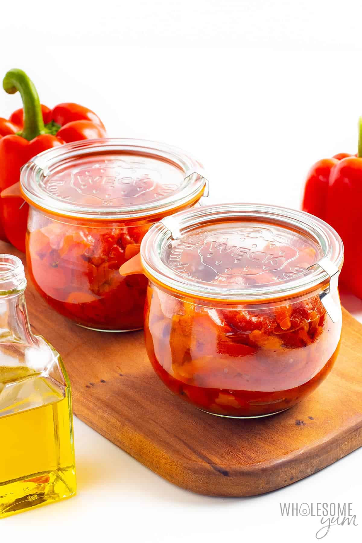 Roasted red pepper recipe in jars on a cutting board